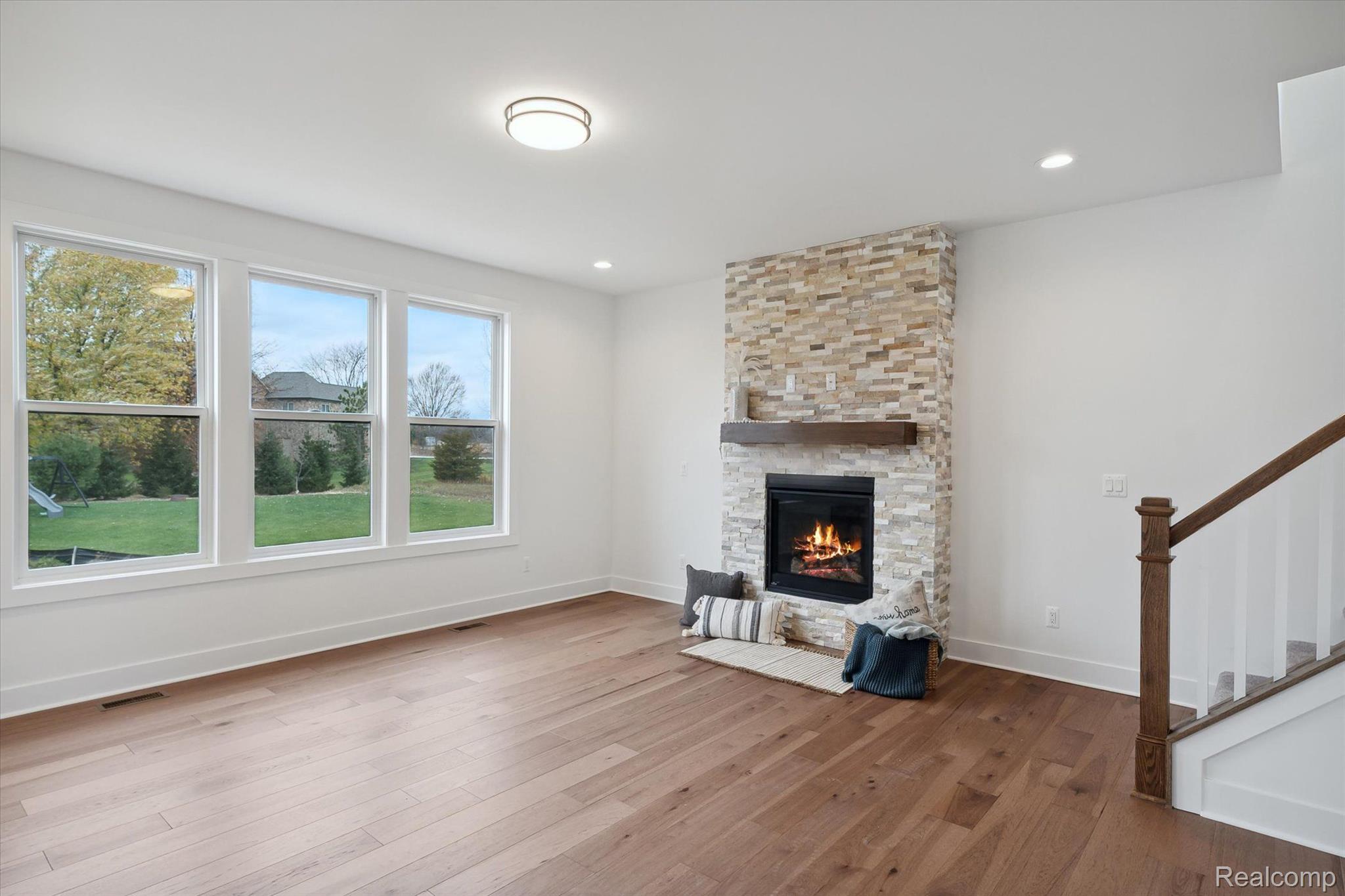 Great room with stone fireplace and staircase
